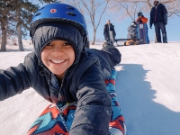 Photo of a child taking a selfie while tobogganing.